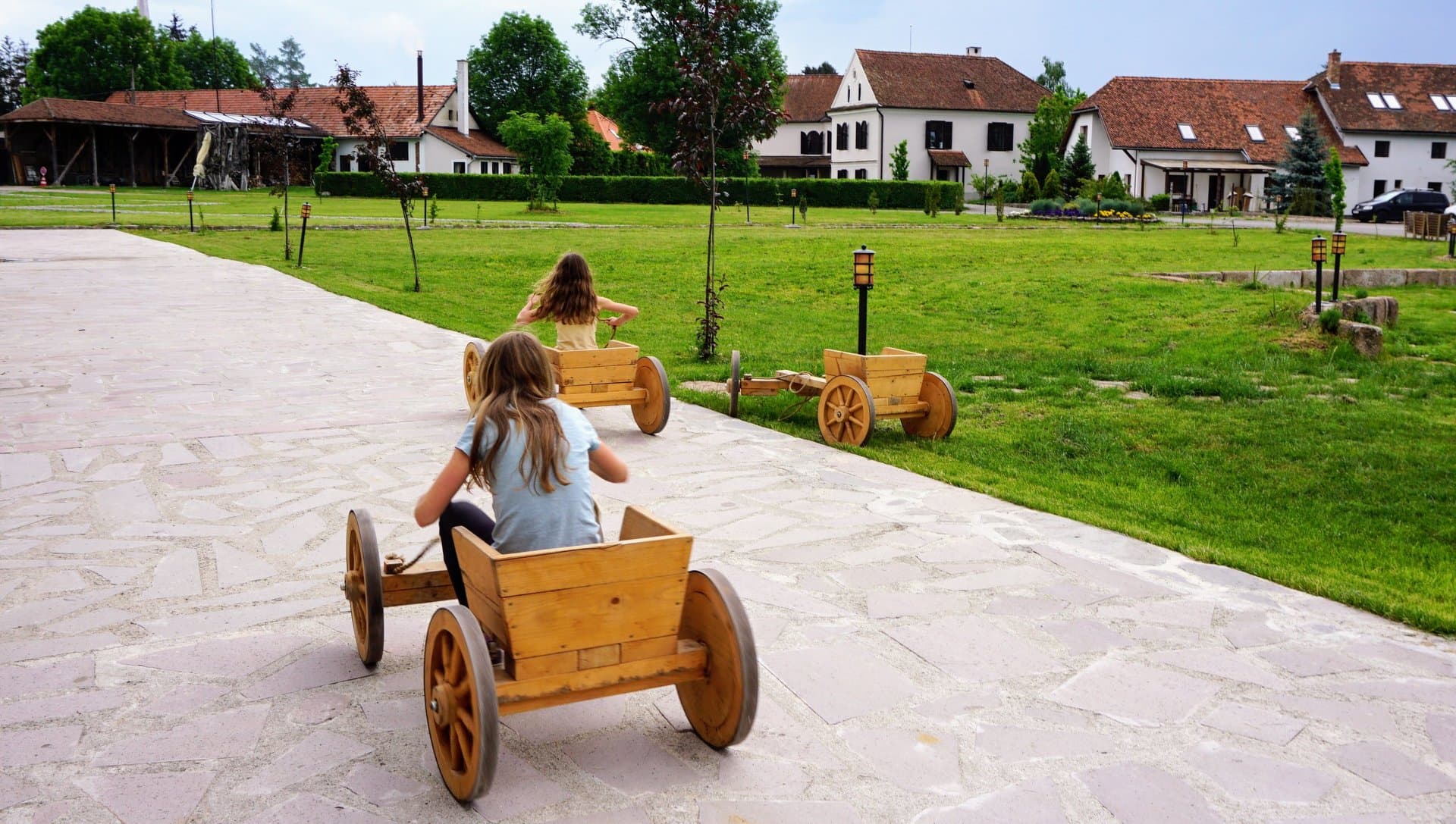 Children playing in wooden carts on the castle grounds